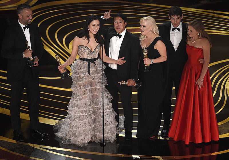 Evan Hayes, from left, Elizabeth Chai Vasarhelyi, Jimmy Chin, Shannon Dill, Alex Honnold, and Sanni McCandless accept the award for best documentary feature for "Free Solo" at the Oscars on Sunday at the Dolby Theatre in Los Angeles.