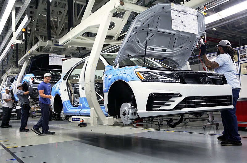 Volkswagen employees work around vehicles moving down the assembly line at the Volkswagen Plant Thursday, Aug. 31, 2017, in Chattanooga, Tenn. 