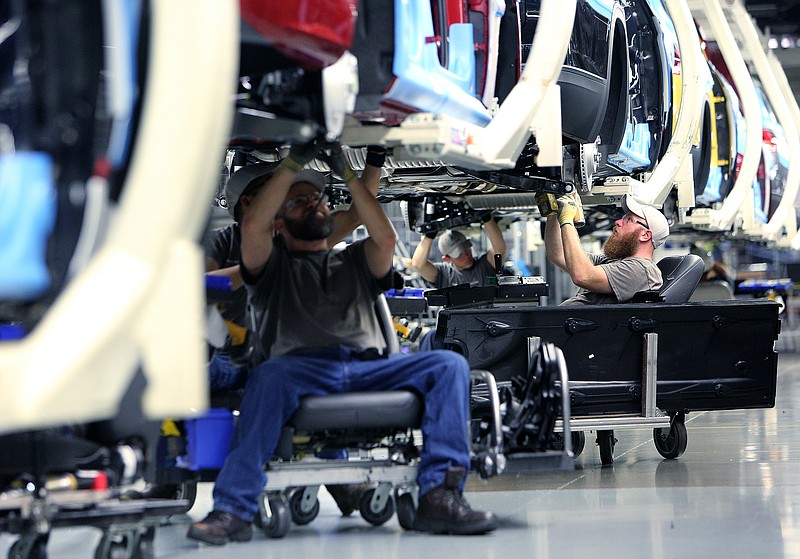 Volkswagen employees work beneath vehicles moving down the assembly line at the Volkswagen Plant Thursday, Aug. 31, 2017, in Chattanooga, Tenn. 