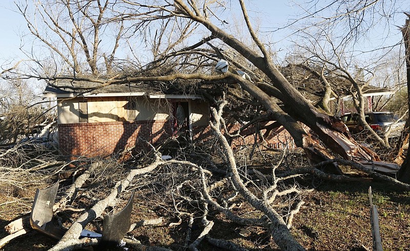 Tornado strewn debris and fallen trees take their toll in this Columbus, Miss., neighborhood, Sunday morning, Feb. 24, 2019. At least one person was killed among the shattered businesses and wrecked homes that dotted the South as severe storms followed a weekend of drenching rains and a rising flood threat. (AP Photo/Rogelio V. Solis)