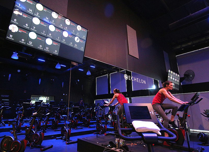 Missy Elliott, an instructor, leads a class at Echelon Studio Wednesday, January 9, 2019 in Chattanooga, Tennessee. While there was one attendees physically in the class, there were several others tuning in through an application as they worked out in other locations. Attendees through the application can be seen on the screen in the upper lefthand corner.