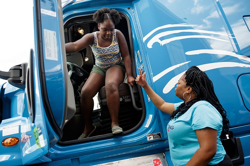 Sharae Moore, right, helps Makayla Craddock down from her semitruck at Brainerd United Methodist Church on Friday, July 20, 2018, in Chattanooga, Tenn. Two women semitruck drivers with Sese Logistics and LTI trucking brought their vehicles for children at the Girls Inc. summer camp to visit as part of the duo's outreach to inspire more girls to consider careers in trucking.