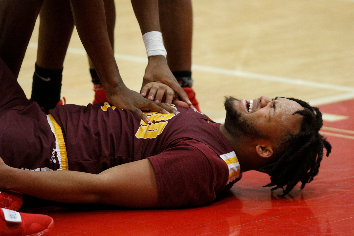 Howard's Marquez Williams grimaces on the court after a hard collision during their Region 3-AA basketball tournament semifinal game against Howard at Loudon High School on Tuesday, Feb. 26, 2019, in Loudon, Tenn. Brainerd won 70-65.