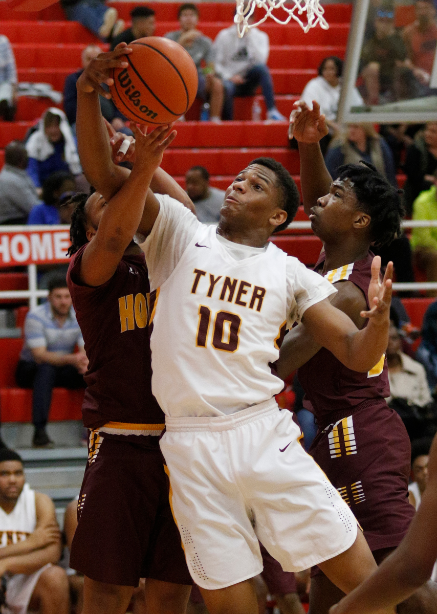 Tyner's Soloman Bridgeman, center, rebounds between Howard's Marquez Williams, left, and Daniel Burks during their Region 3-AA basketball tournament semifinal game at Loudon High School on Tuesday, Feb. 26, 2019, in Loudon, Tenn. Brainerd won 70-65.