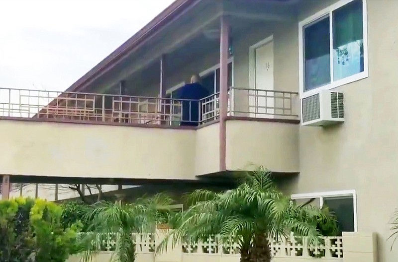 In this still image taken from video, an investigator is seen at the apartment building where authorities say a mother threw her young son from a second-story apartment landing and jumped herself as police arrived in Upland, Calif., Tuesday, Feb. 26, 2019. The mother and 1-year-old boy were hospitalized in stable condition, police said. A baby girl was found dead inside their apartment. (Beatriz Valenzuela/The Orange County Register/SCNG via AP)

