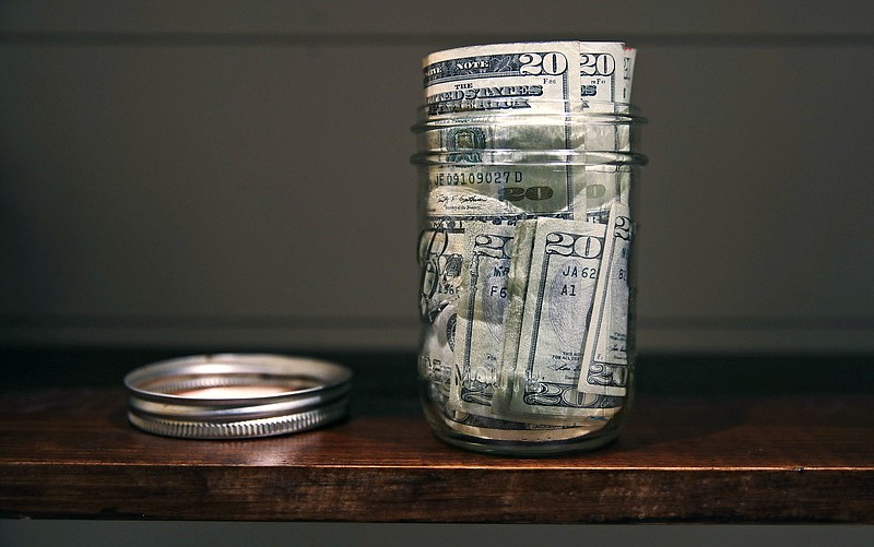 FILE - In this June 15, 2018, file photo a canning jar filled with currency sits on a shelf in East Derry, N.H. An emergency fund doesn’t have to be wishful thinking when you’re building your financial life. Start small to build a habit, use windfalls to kick-start your fund and have a plan for irregular expenses. (AP Photo/Charles Krupa, File)