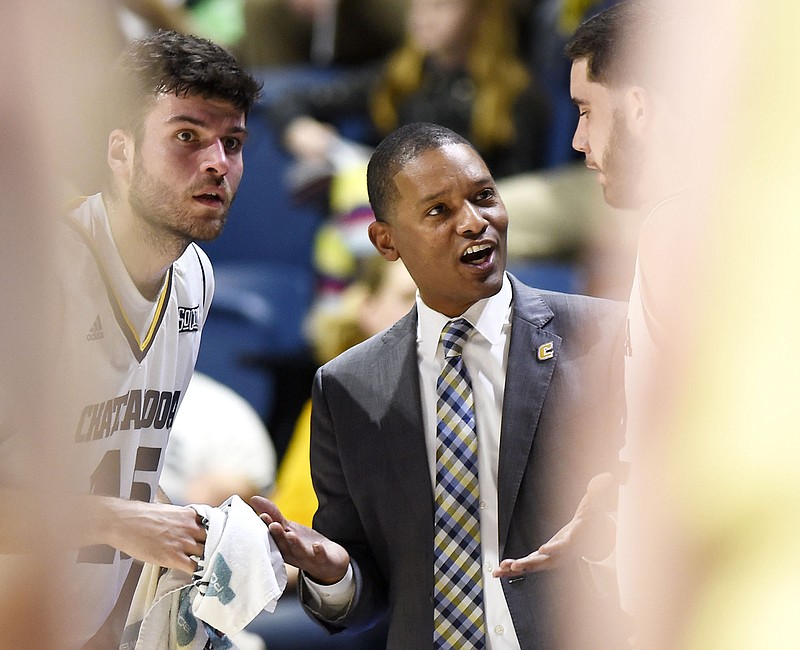 UTC men's basketball coach Lamont Paris, center, confers with Roman Vila, left, and Keigan Kerby during Thursday night's home game against SoCon leader Wofford.  