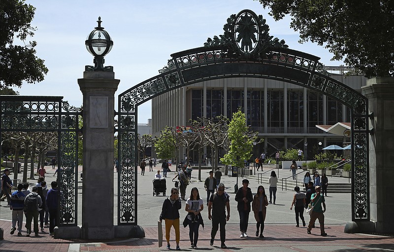 FILE - In this May 10, 2018, file photo, students walk past Sather Gate on the University of California at Berkeley campus in Berkeley, Calif. Choosing a college based on price can save you from overwhelming student debt, give your parents a break and increase the likelihood of a return on investment in your education.  (AP Photo/Ben Margot, file)