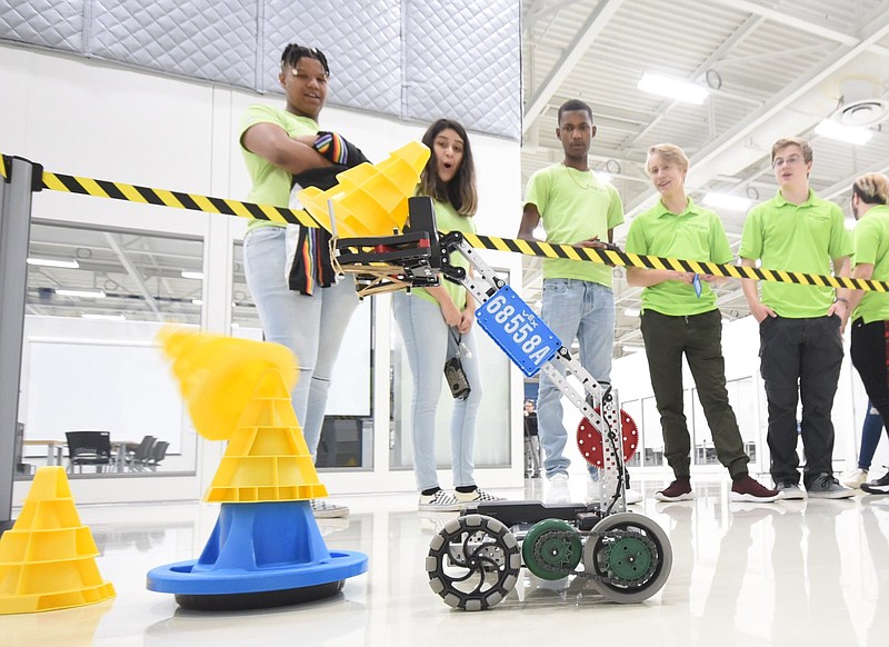 Caleb Franklin, Tara Gurrola, Jordan Kirby, Marko Burdeiniy and Issac Guardiani, from left, current students in the Mechatronics Akademie, watch a unit from the VEX EDR Robotics Competition.