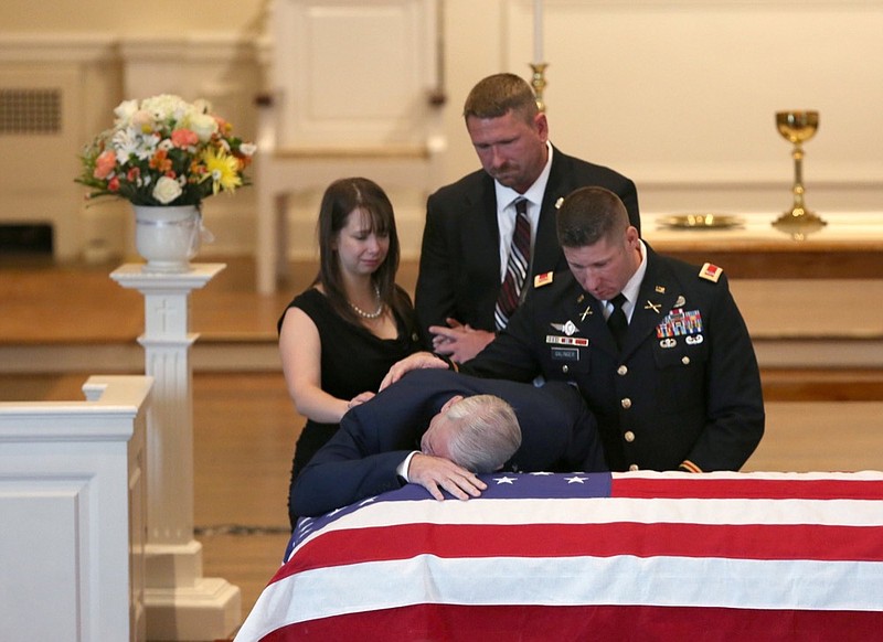 Barry Galinger, the father of fallen Chattanooga police officer Nicholas Galinger, lies his head on his son's casket with his kids behind him after delivering words of remembrance during his son's funeral at Mt. Washington Presbyterian Church Friday, March 1, 2019 in Cincinnati, Ohio. The day prior Barry acknowledge that moment would be the last time he was able to see his son.