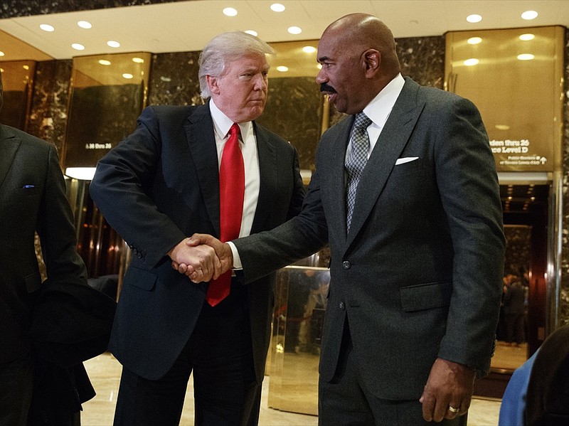 FILE - In this Jan. 13, 2017, file photo, President-elect Donald Trump shakes hands with comedian Steve Harvey in the lobby of Trump Tower in New York. The "black friend defense" played out before a national TV audience during this week's congressional testimony of Michael Cohen, President Donald Trump's former lawyer. (AP Photo/Evan Vucci, File)

