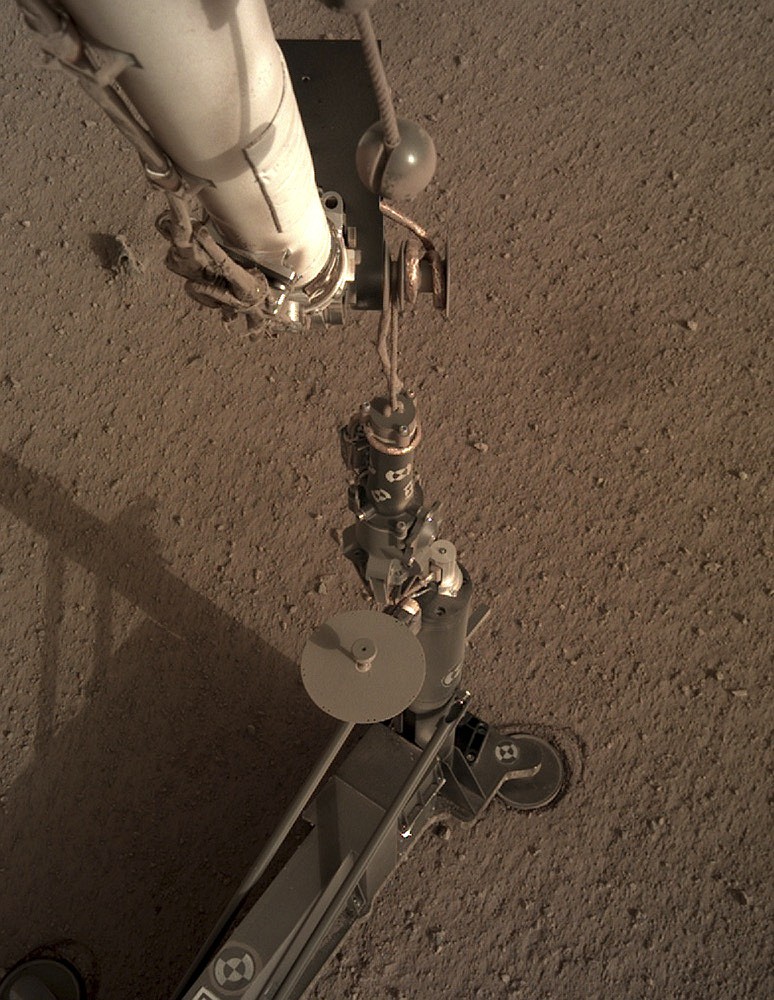 This photo provided by NASA/JPL-Caltech shows an image acquired by NASA's InSight Mars lander using its robotic arm-mounted, Instrument Deployment Camera (IDC). The image was acquired on March 1, 2019, Sol 92 where the local mean solar time for the image exposures was 16:53:31.055 PM. Scientists say NASA's newest Mars lander has started digging into the red planet, but has hit a few snags. (NASA/JPL-Caltech via AP)

