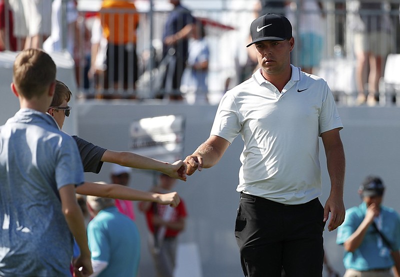 Keith Mitchell fist-bumps a group of children as he heads to the 10th tee during the final round of the Honda Classic on Sunday in Palm Beach Gardens, Fla.