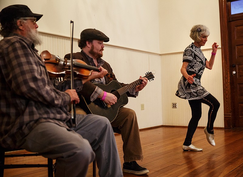 Mick Kinney, left, and his son, Evan Kinney, play music while Laurie Jo Ramond competes in the dance contest at the 2018 Great Southern Old Time Fiddlers' Convention.