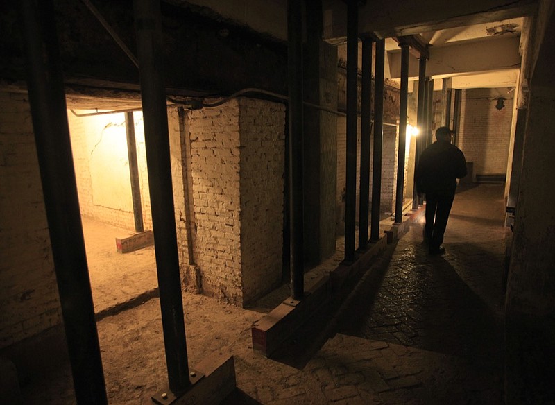 File - In this July 7, 2011, file photo, Jim Breeden of the Golden Gate National Parks Conservancy, walks through the dungeons below the main cell house during a night tour on Alcatraz Island in San Francisco. Archaeologists have confirmed a long-time suspicion of historians: the famed Alcatraz prison was built over a Civil War-era military fortification. SFGate reports researchers have found a series of buildings and tunnels under the prison yard of Alcatraz Federal Penitentiary, which once held Al Capone. (AP Photo/Eric Risberg, File)

