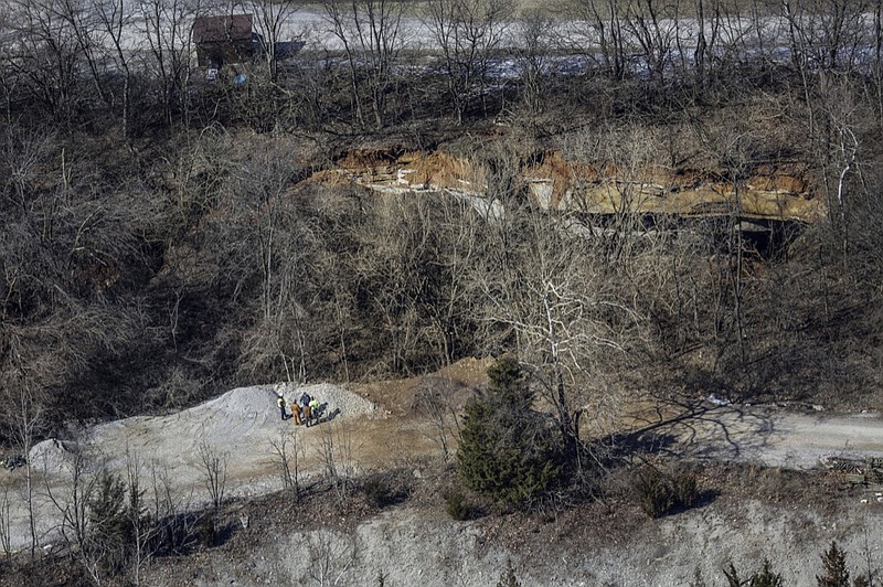 Officials stand on one edge of a giant sinkhole on the property of the Louisville Zoo, Wednesday, March 6, 2019, in Louisville, Ky. Louisville Zoo spokeswoman Kyle Shepherd told news outlets the sinkhole was found Wednesday in an undeveloped area away from any zoo animals. She said no people or animals were reported injured and no buildings damaged. (Jeff Faughender/Courier Journal via AP)

