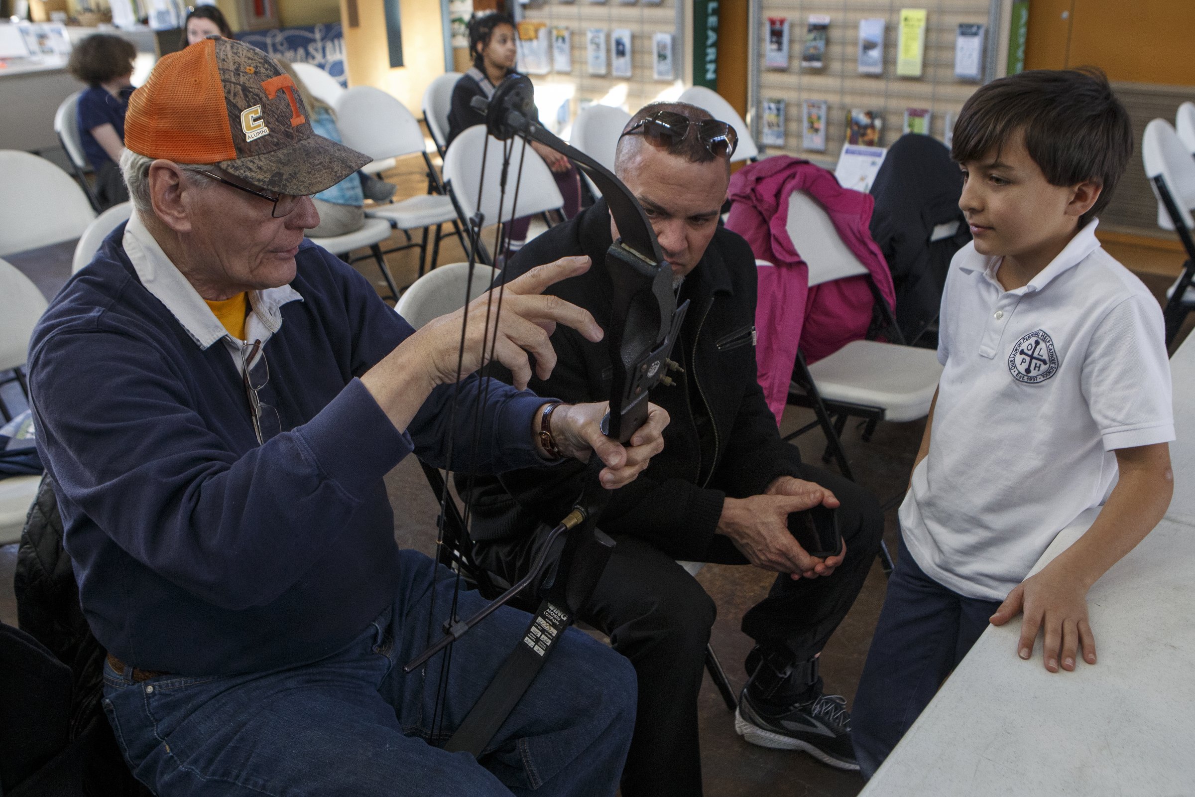 Norm Jensen, left, talks about the tension in a bow with Jamie Stafford, center, and his 10-year-old son James at Outdoor Chattanooga on Wednesday, March 6, 2019 in Chattanooga, Tenn. Outdoor Chattanooga is offering the free "Try Archery" program every Wednesday through the end of March from 3:30-6 p.m. No previous experience is required and equipment is provided.