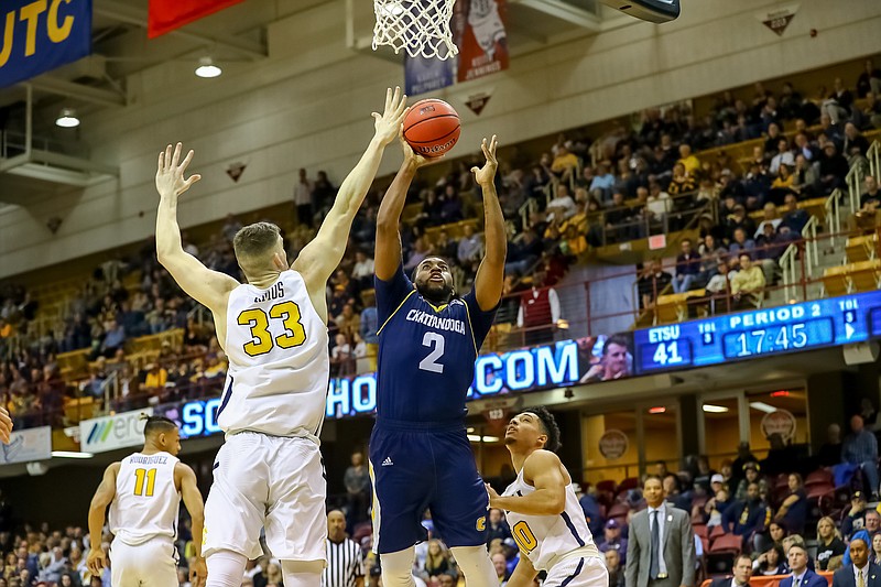 UTC's Jerry Johnson Jr. shoots while guarded by ETSU's Mladen Armus during a SoCon tournament quarterfinal game Saturday in Asheville, N.C.