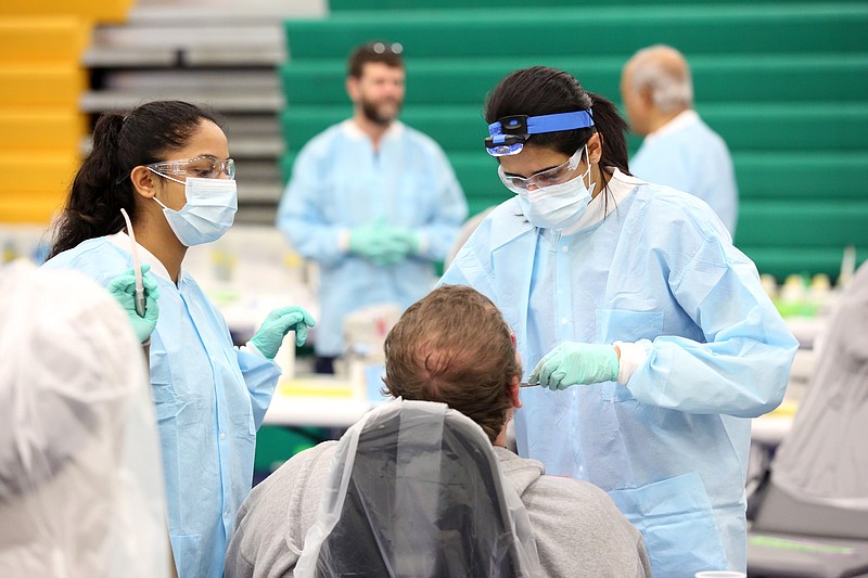 Shriya Rao, a pre-dental student at Appalachian State University, and Nakita Patel, an international dentist and dental student at Tufts University, work on a patient at a free clinic hosted by Remote Area Medical Sunday, March 10, 2019 at Rhea County Middle School in Evensville, Tennessee. The clinic was done at no cost to patients with most of the funding coming from private donors. 
