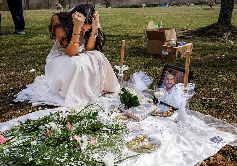 Clad in a wedding dress, Sara Baluch mourns while visiting the grave of her fiance, Mohammad Sharifi, on Sunday, March 10, 2019, the day after they were supposed to be married, at Harpeth Hills Memory Gardens in Nashville, Tenn. Sharifi, a UTC student, was shot and killed two weeks before their wedding by a man to whom he was trying to sell an Xbox.