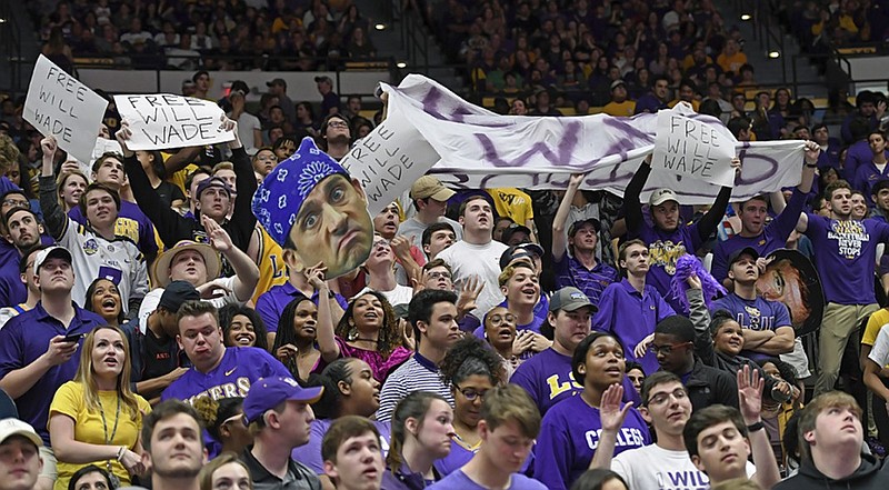 Fans in the LSU student section wave banners and signs supporting suspended coach Will Wade during the school's men's basketball game against Vanderbilt on Saturday night in Baton Rouge, La.