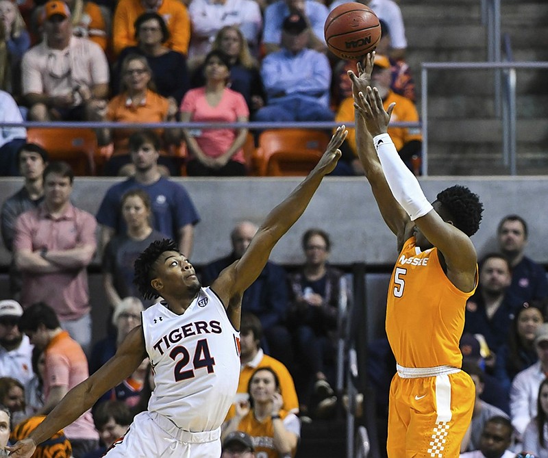 Auburn forward Anfernee McLemore (24) leaps out to defend against a shot by Tennessee guard Admiral Schofield during the second half of their teams' regular-season finale Saturday in Auburn, Ala