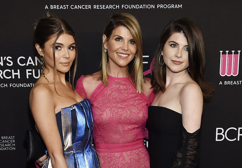 In this Feb. 28, 2019 file photo, actress Lori Loughlin, center, poses with daughters Olivia Jade Giannulli, left, and Isabella Rose Giannulli at the 2019 "An Unforgettable Evening" in Beverly Hills, Calif. Loughlin and her husband Mossimo Giannulli were charged along with nearly 50 other people Tuesday in a scheme in which wealthy parents bribed college coaches and other insiders to get their children into some of the most elite schools in the country, federal prosecutors said. (Photo by Chris Pizzello/Invision/AP, File)