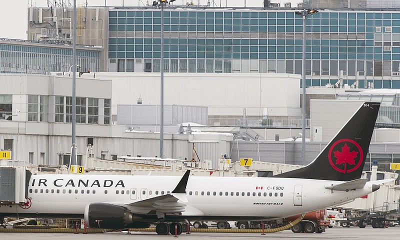 An Air Canada Boeing 737 Max 8 aircraft is parked next to a gate at Trudeau Airport in Montreal, Wednesday, March 13, 2019. Canada's transport minister says the country is closing air space to the Boeing 737 Max 8 jet following the crash of an Ethiopian Airlines jetliner. (Graham Hughes/The Canadian Press via AP)