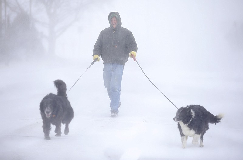 Tom Skaar of Cheyenne laughs while walking his dogs on House Avenue during a blizzard on Wednesday, March 13, 2019, in Cheyenne, Wyo. White-out conditions closed I-80, I-25, and U.S. 85, effectively closing off the state capital from Nebraska, Colorado and the rest of Wyoming. (Jacob Byk/The Wyoming Tribune Eagle via AP)

