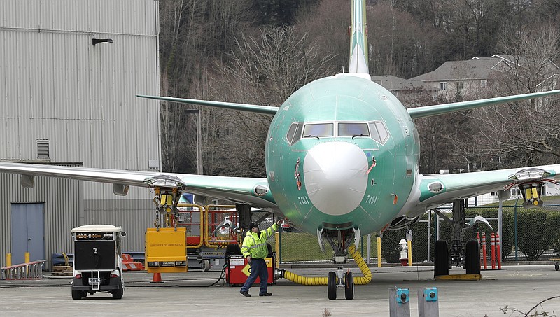 FILE- In this March 11, 2019, file photo a worker stands near a Boeing 737 MAX 8 airplane parked at Boeing Co.'s Renton Assembly Plant in Renton, Wash. Boeing soared early in 2019 and lifted the Dow Jones Industrial Average with it. Now concerns about the safety of the newest version of its flagship airplane have halted the momentum. (AP Photo/Ted S. Warren, File)