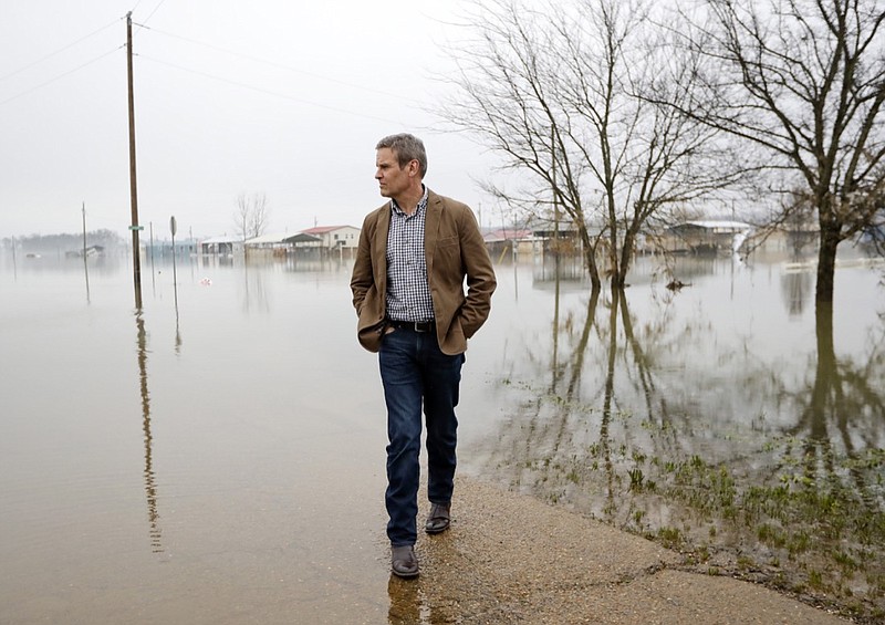 Tennessee Gov. Bill Lee looks over flooding from the Tennessee River Friday, March 8, 2019, in Savannah, Tenn. Lee has signed an executive order making it easier for Tennessee to recover from the effects of serious flooding caused by heavy rains. (AP Photo/Mark Humphrey)