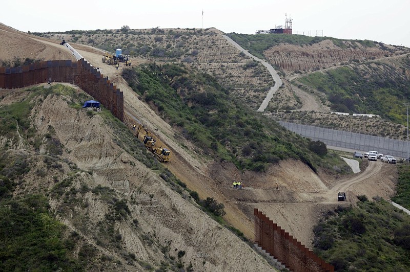 Construction crews replace a section of the primary wall separating San Diego, above right, and Tijuana, Mexico, below left, Monday, March 11, 2019, seen from Tijuana, Mexico. President Donald Trump is reviving his border wall fight, preparing a new budget that will seek $8.6 billion for the U.S-Mexico barrier while imposing steep spending cuts to other domestic programs and setting the stage for another fiscal battle. (AP Photo/Gregory Bull)

