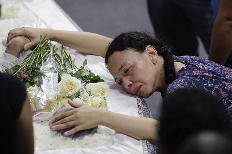 A relative mourns 15-year-old Caio Oliveira, a victim of a mass shooting at the Raul Brasil State School, in Suzano, Brazil, Thursday, March 14, 2019. Classmates, friends and families began saying goodbye on Thursday, with thousands attending a wake in the Sao Paulo suburb while authorities worked to understand what drove two former students to attack the school with a gun, crossbows and small axes. (AP Photo/Andre Penner)

