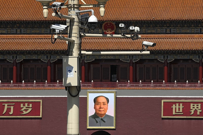 Surveillance cameras are mounted on a lamp post near the large portrait of Chinese leader Mao Zedong at the Tiananmen Gate in Beijing, Friday, March 15, 2019. Chinese Premier Li Keqiang on Friday denied Beijing tells its companies to spy abroad, refuting U.S. warnings that Chinese technology suppliers might be a security risk. (AP Photo/Andy Wong)