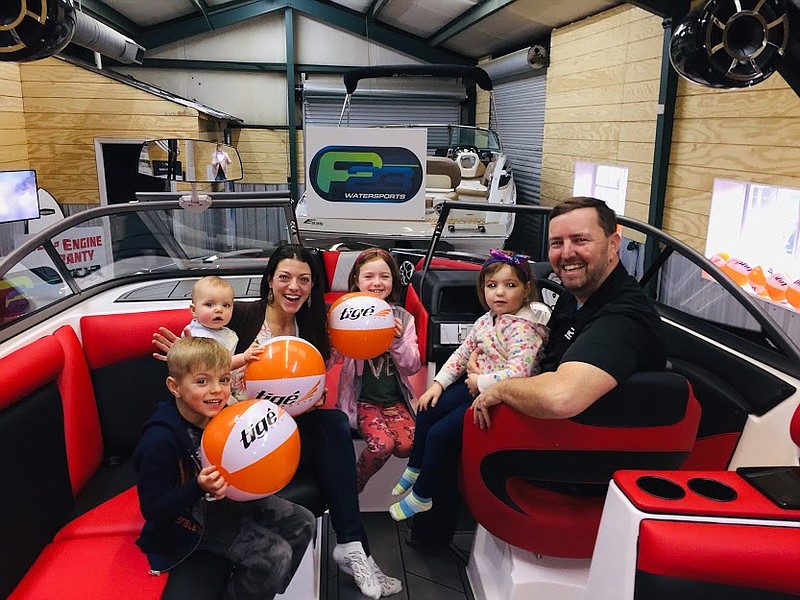 P23 Watersports co-owner Mark Newton gathers with family members in a boat by Tige, the top-selling brand at the Harrison boat dealership. From left are Maximo, Tobias, Nia, Sophia, Evangelina and Mark Newton. / Photo contributed by Jeff Herron