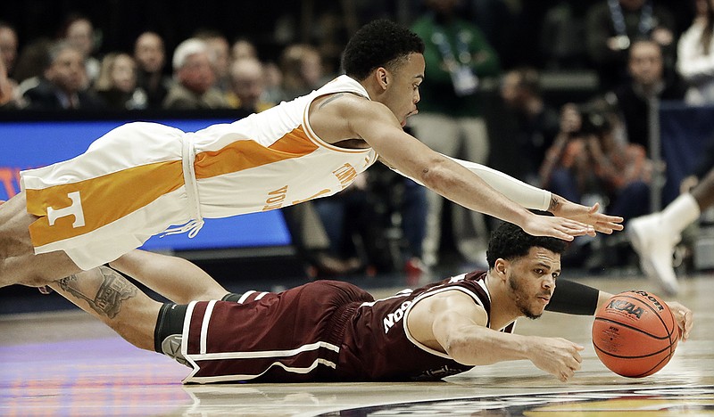 Tennessee's Lamonte Turner, top, and Mississippi State's Quinndary Weatherspoon dive for a loose ball in the second half of an SEC tournament quarterfinal Friday night at Bridgestone Arena in Nashville. Tennessee won 83-76 to advance to a semifinal against rival Kentucky.