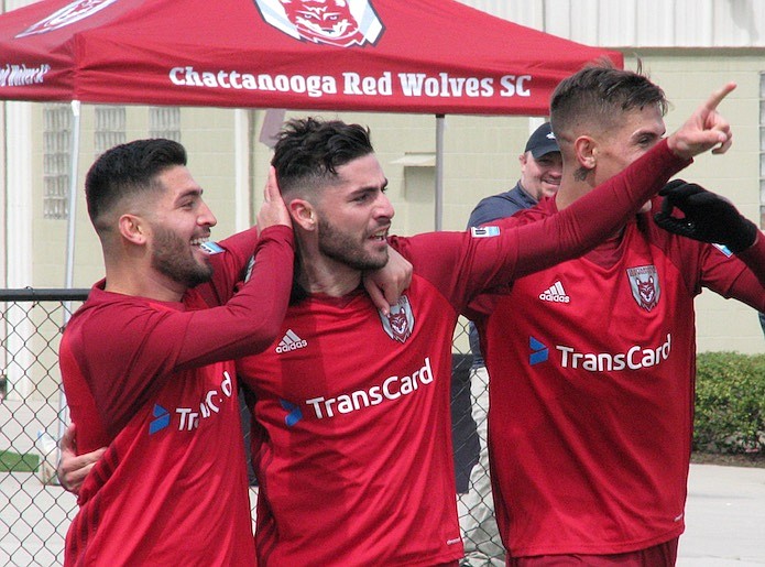 Chattanooga Red Wolves defender Jonathan Caparelli, center, celebrates with teammates after scoring in the 88th minute against Louisville City FC during an exhibition match Saturday at Chattanooga Christian School. The soccer teams played to a 1-1 draw.