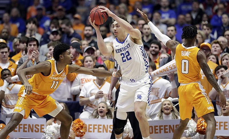 Kentucky forward Reid Travis (22) protects the ball from Tennessee defenders Kyle Alexander, left, and Jordan Bone during their SEC tournament semifinal Saturday in Nashville.