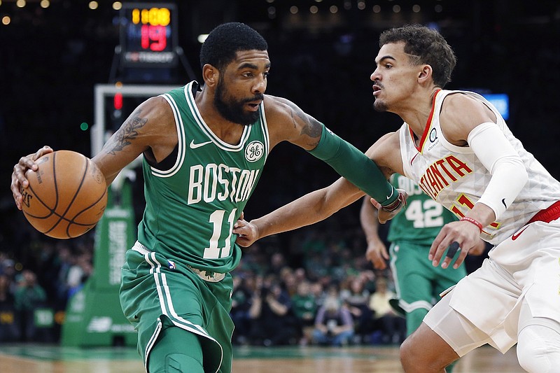 Boston Celtics point guard Kyrie Irving, left, drives past Atlanta Hawks rookie Trae Young during the first half of Saturday's game in Boston.