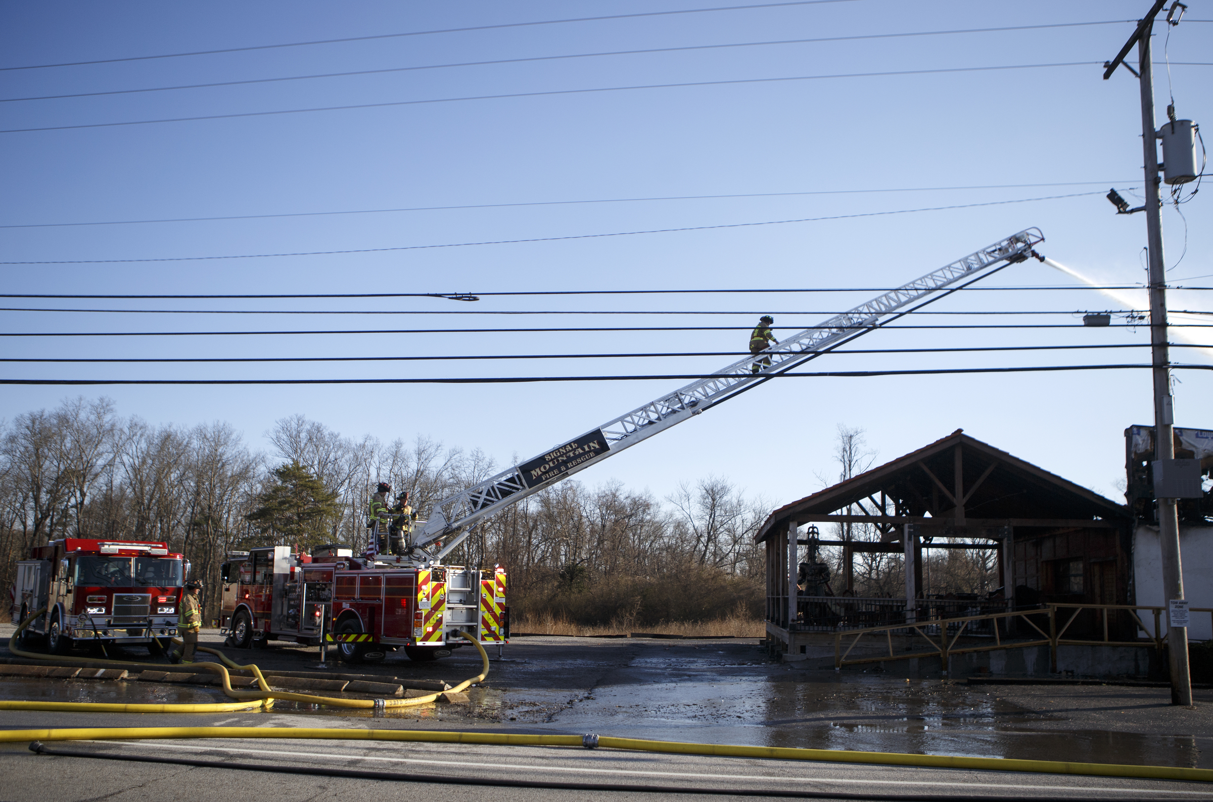 A firefighter climbs the ladder while working a fire at Patron Mexican Grill located at 3720 Taft Highway on Monday, March 18, 2019 in Signal Mountain, Tenn.