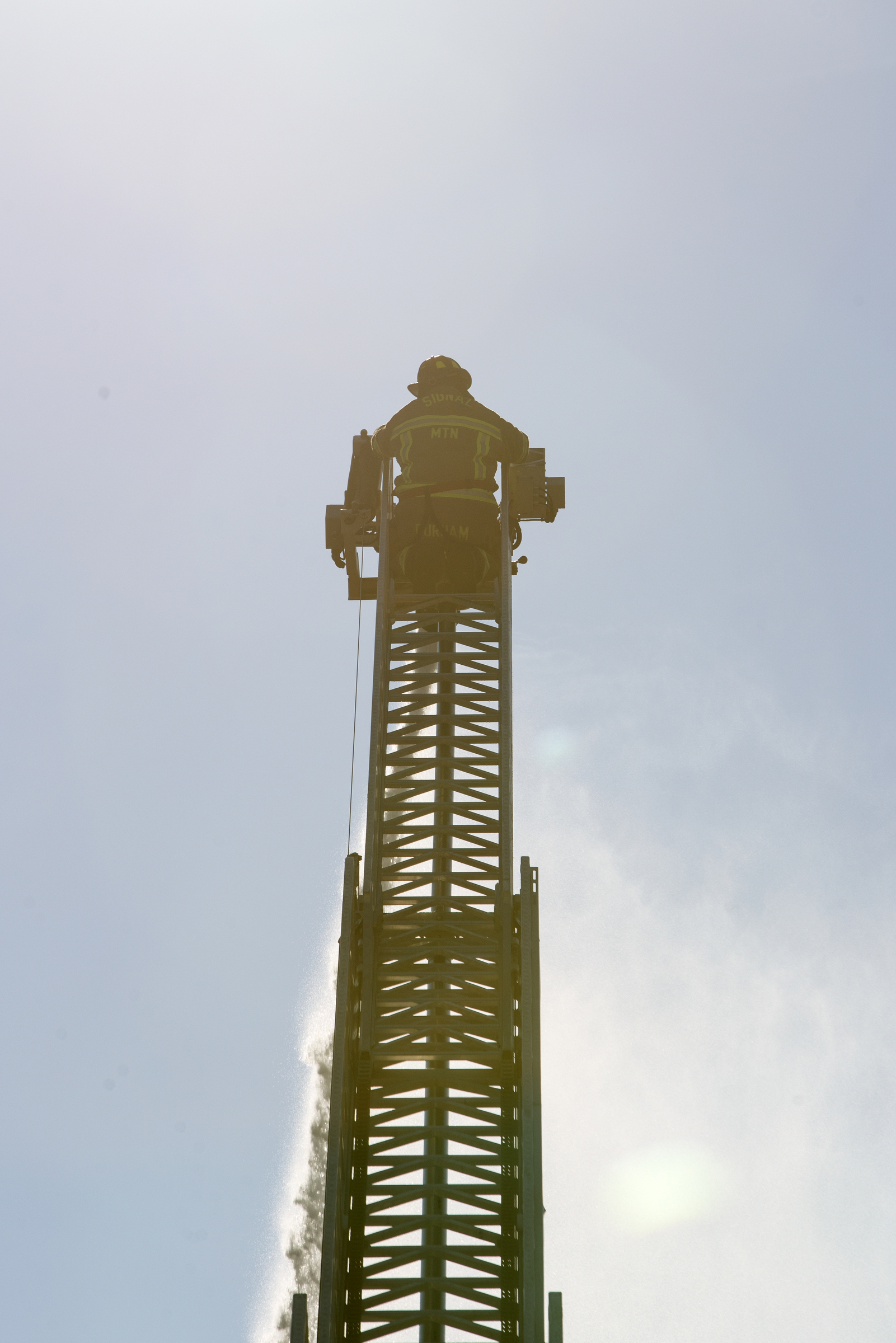 A firefighter works from the top of a ladder while working to put out a fire at Patron Mexican Grill located at 3720 Taft Highway on Monday, March 18, 2019 in Signal Mountain, Tenn.