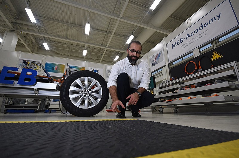 Ilker Subasi, assistant manager of technical training at Volkswagen Chattanooga, talks about an anti-static surface that VW employees can stand on while assembling electric vehicles at the plant.