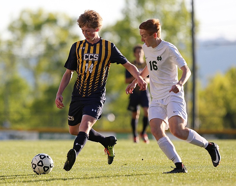 Chattanooga Christian School's Daniel Reinink (14) pushes the ball downfield while Notre Dame's Justin Hensley runs beside him during a match at Notre Dame in April 2018.