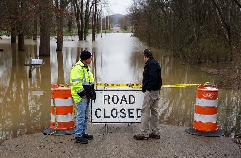 Kenny Kinnaman with Chattanooga Public Works, left, and an individual who did not want to give his name survey floodwaters covering Aster Road in Lookout Valley after heavy rainfall on Wednesday, Feb. 20, 2019, in Chattanooga, Tenn. Continuous rain through the week has raised area waterways to flood stages, with more rain expected in the coming days.