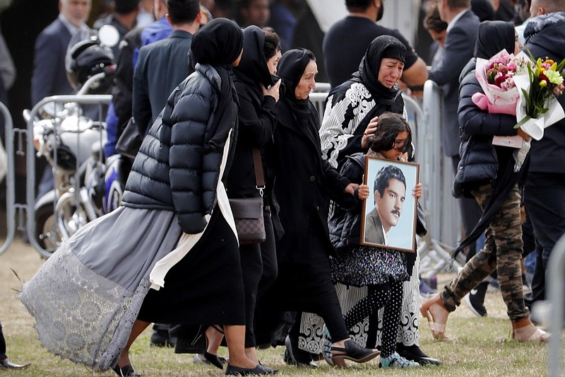 Mourners arrive for a burial service of a victim from the March 15 mosque shootings at the Memorial Park Cemetery in Christchurch, New Zealand, Thursday, March 21, 2019. (AP Photo/Vincent Thian)


