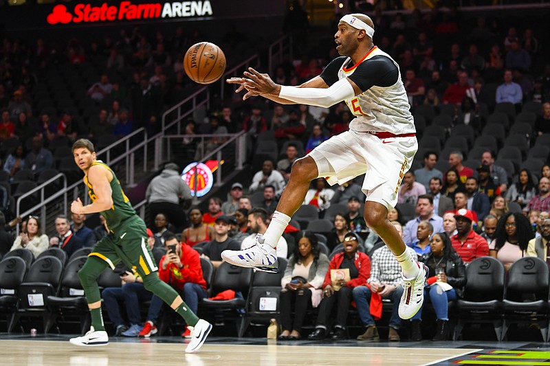 Atlanta Hawks forward Vince Carter passes the ball after saving it from going out of bounds during the first half of Thursday night's game against the Utah Jazz in Atlanta.