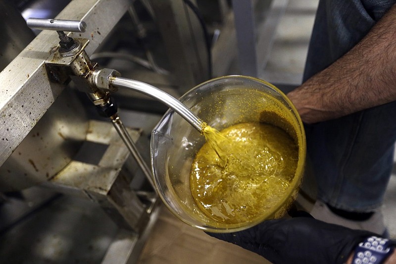 In this April 24, 2018, file photo, the first rendering from hemp plants extracted from a super critical CO2 extraction device on its' way to becoming fully refined CBD oil spurts into a large beaker at New Earth Biosciences in Salem, Ore. From skin-care lotions to bottled water, cannabis companies are rolling out a growing array of consumer products infused with a chemical found in marijuana called cannabidiol, or CBD. (AP Photo/Don Ryan, File)