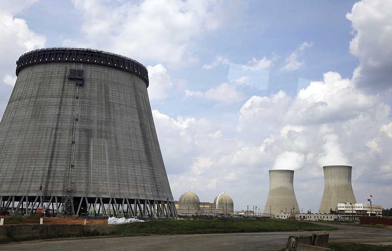 In this June 13, 2014, file photo, a new cooling tower for a nuclear power plant reactor that's under construction stands near the two operating reactors at Plant Vogtle power plant in Waynesboro, Ga. Energy Secretary Rick Perry announced Friday, March 22, 2019, that the Trump administration has finalized $3.7 billion in new loan guarantees to support completion of the first new U.S. commercial nuclear reactors in a generation, calling the expansion of nuclear energy "the real" Green New Deal. (AP Photo/John Bazemore, File)