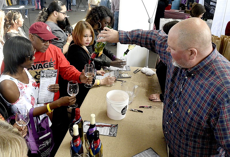 Jeremy Dalton, right, vineyard manager for Tsali Notch Vineyard of Madisonville, Tn., pours for wine fans.  The Tennessee Farm Winegrowers Alliance hosted the SipTN Chattanooga Wine Festival at the First Tennessee Pavilion on March 23, 2019.  