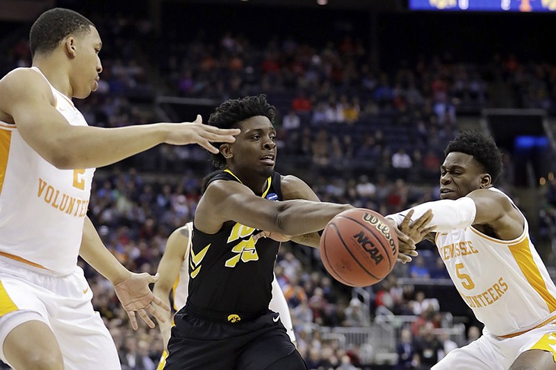 Iowa's Tyler Cook, center, passes between Tennessee's Grant Williams, left and Admiral Schofield during the first half of their NCAA tournament second-round game Sunday in Columbus, Ohio.